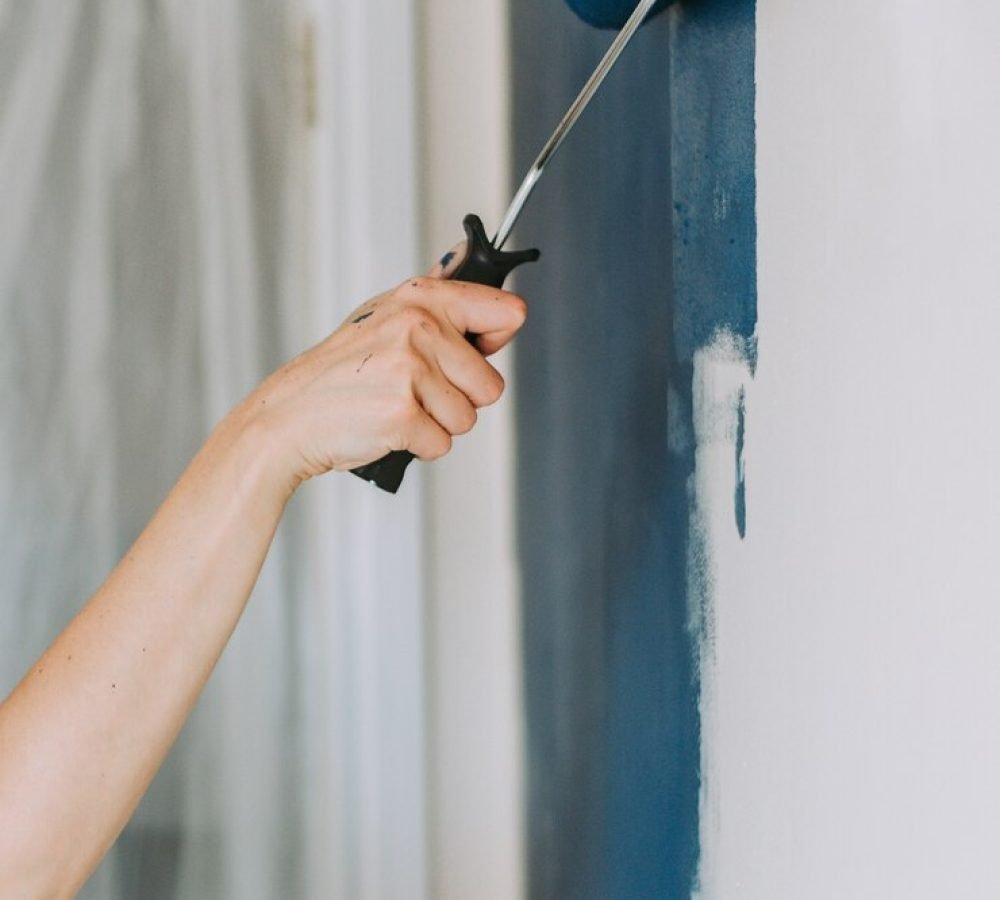 closeup-shot-person-using-paint-rollers-with-color-blue_181624-2451